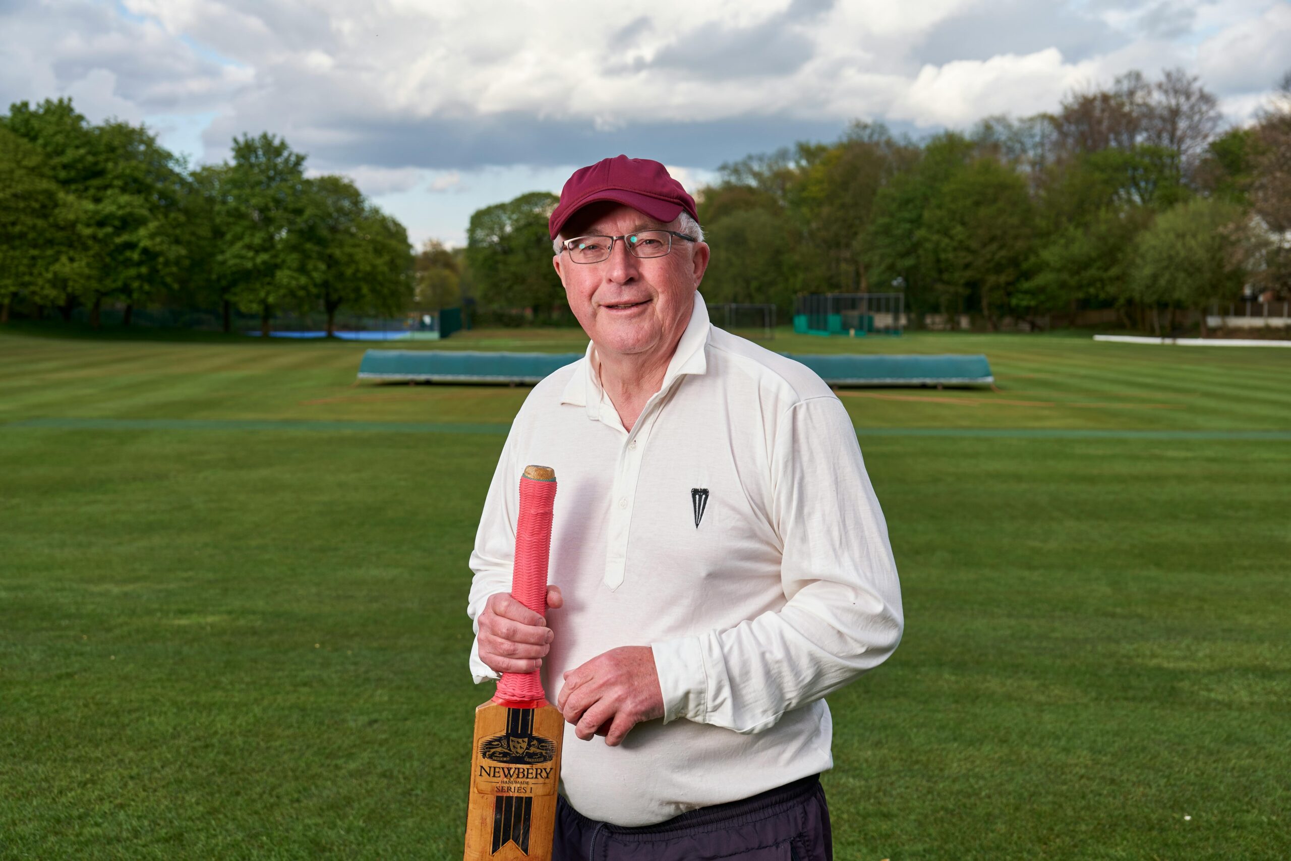 Elderly man holding a cricket bat